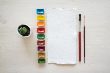Paper and watercolor pack containing pastel shades, table, and paper