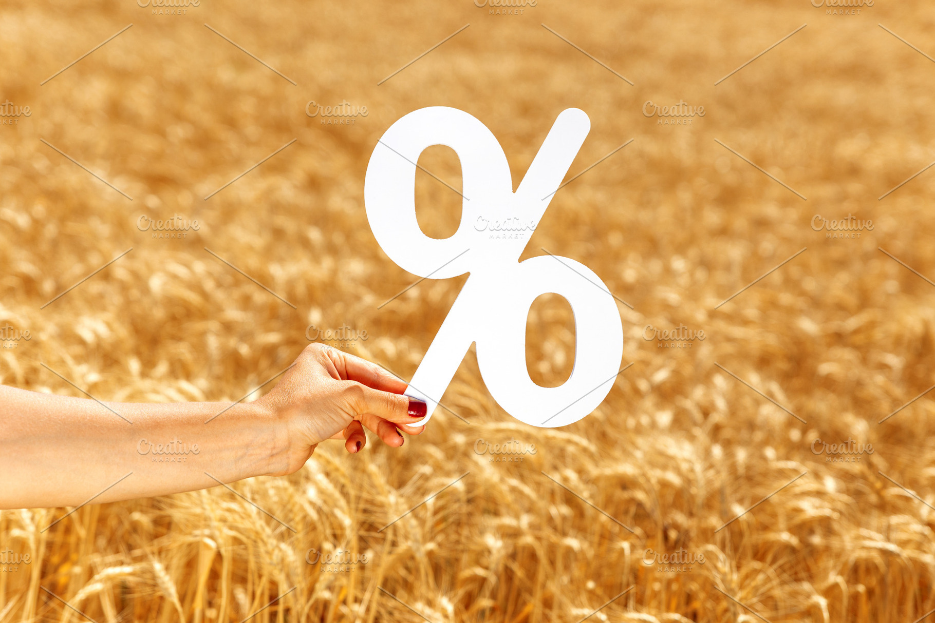 Female hand holding a large white percent symbol over a golden w, a Business Photo by Ales Munt