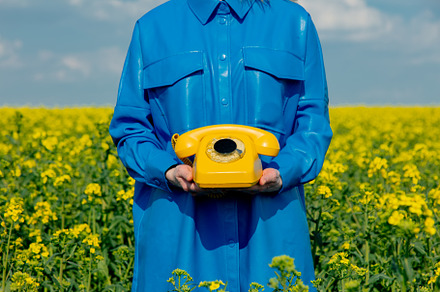 Ukrainian woman with yellow telephone in rapeseed field in sprin, a Person Photo by Masson Simon