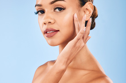 Skincare, beauty and portrait of woman with makeup, wellness and glow on blue background. Cosmetics, dermatology and model with hand on face, luxury facial care and healthy spa aesthetic in studio., a Photo by Peopleimages.com