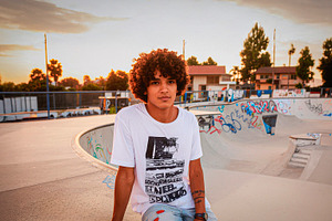 Curly haired teenager at community skatepark, a Person Photo by DanFLCreativo