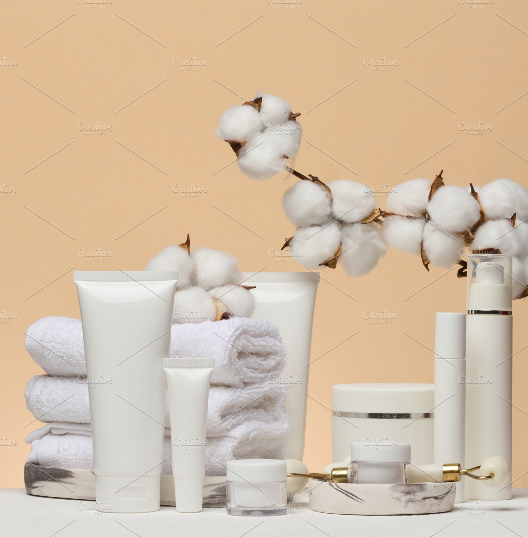 Various white cosmetics, a stack of towels and a cotton branch o, a Beauty & Fashion Photo by ndanko