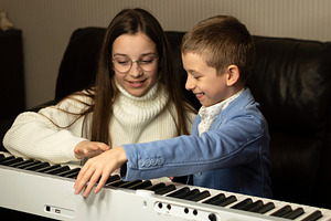Young boy and teen girl play piano, a School & Education Photo by Elena Vagengeim