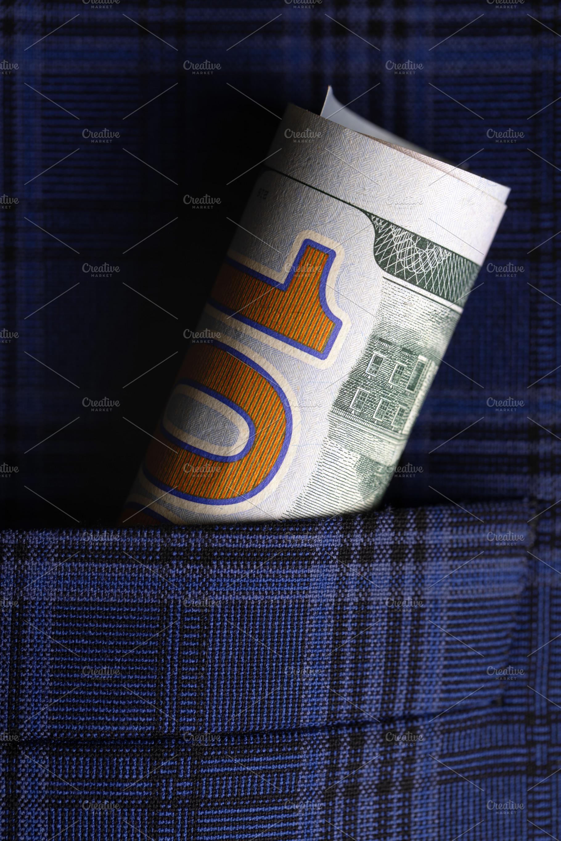 Rolled ten dollar bill tucked into a blue plaid shirt pocket, symbolizing savin, a Business Photo by Ales Munt