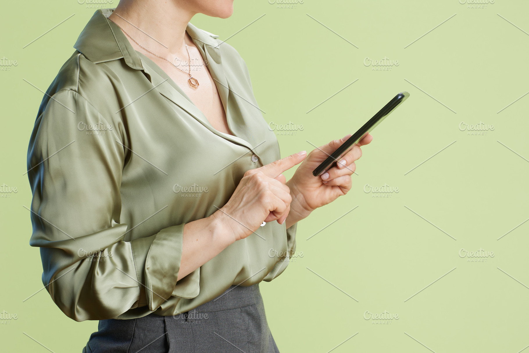 Professional woman tapping smartphone in studio setting, a Business Photo by Alliance Images