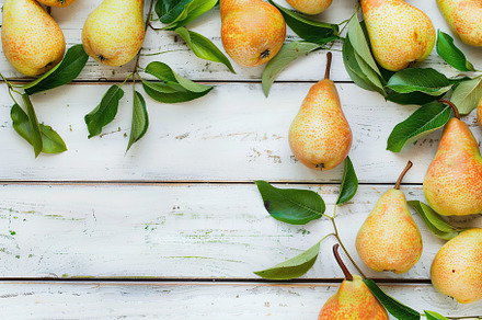 Red pears with leafs and copyspace for text on wooden table, a Food & Drink Photo by AlyaAnd