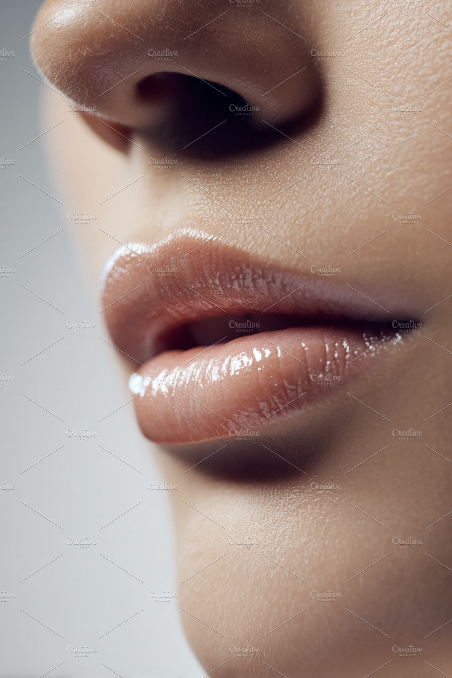 Close up of a female applying lip gloss on plump, glossy lips, s, a Beauty & Fashion Photo by Studio ANNA