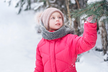 Little girl in a bright jacket plays in the winter forest, a Person Photo by Olena Rudo