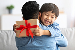 Father hugging his child after receiving a handmade fathers day, a Person Photo by DanFLCreativo