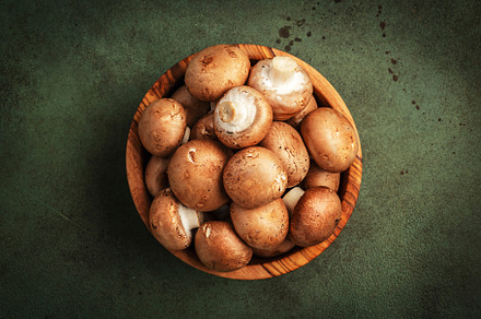 Fresh brown champignon mushrooms in wooden bowl, green stone kit, a Food & Drink Photo by 5PH