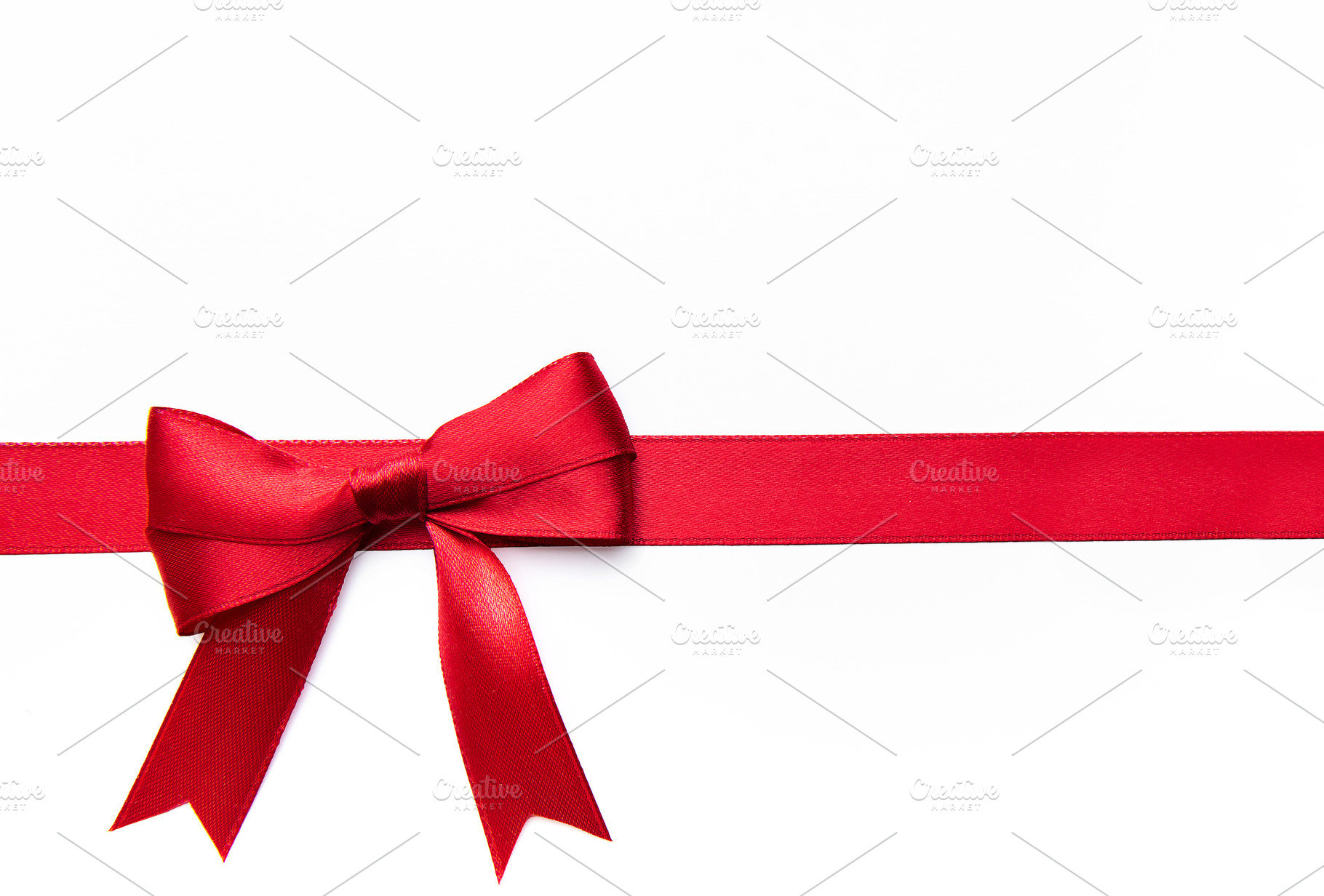 Red satin ribbon bow on white background, a Holiday Photo by Olena Rudo