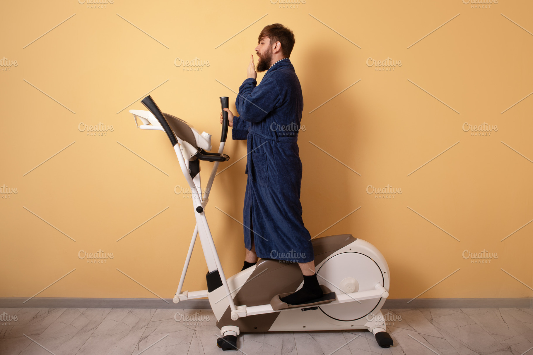 Young man in blue bathrobe yawning while standing on an exercise, a Person Photo by Ales Munt