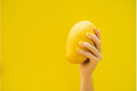 Hand with a yellow manicure holding, a Food & Drink Photo by Elizaveta Galitskaya