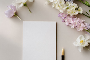 Blank vertical card with pen and fresh stock flowers creating a, a Photo by Studio ANNA