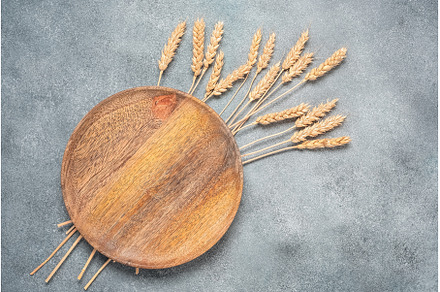 Empty wooden plate and ripe ears of