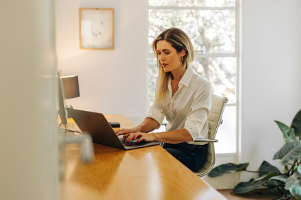 Focused businesswoman typing on a laptop in her office, a Person Photo by Jacob Lund