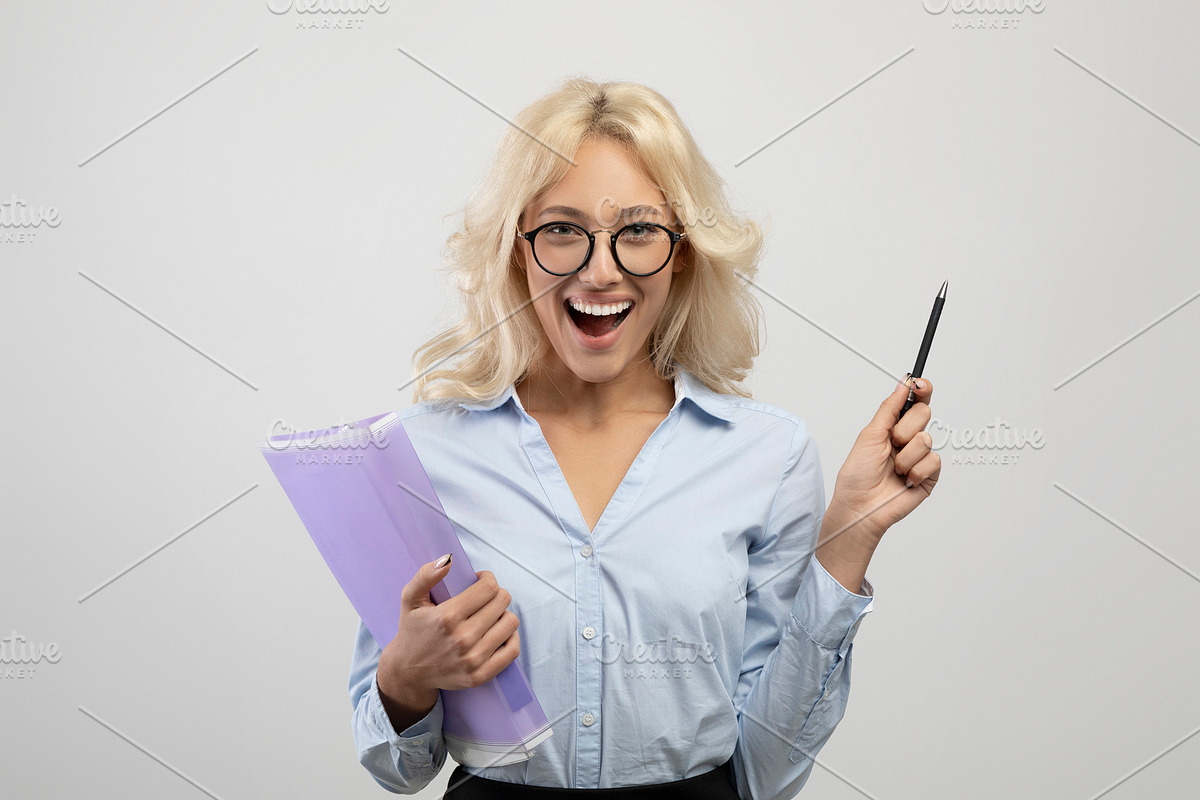 Overjoyed female entrepreneur in formal wear holding folder with documents and, a Photo by Prostock-Studio (Photo 2 of 2)