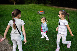 Three children playing outdoors in a park in Lancut, Poland, sunny afternoon, a Photo by AS photostudio
