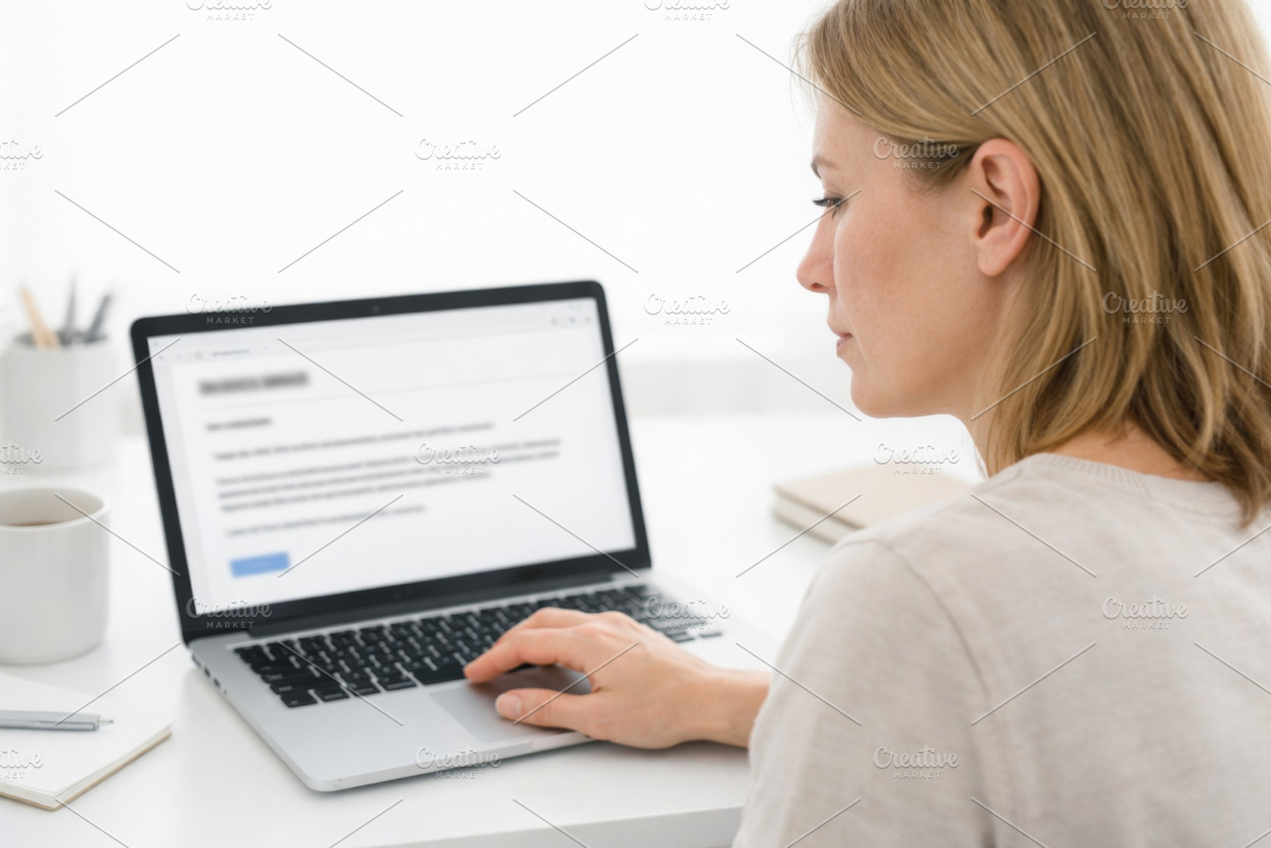 Woman working on laptop at desk in m, a Photo by Dvoevnore photos