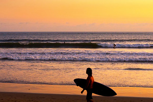 Surfer on beach at sunset containing bali, beach, and surfing