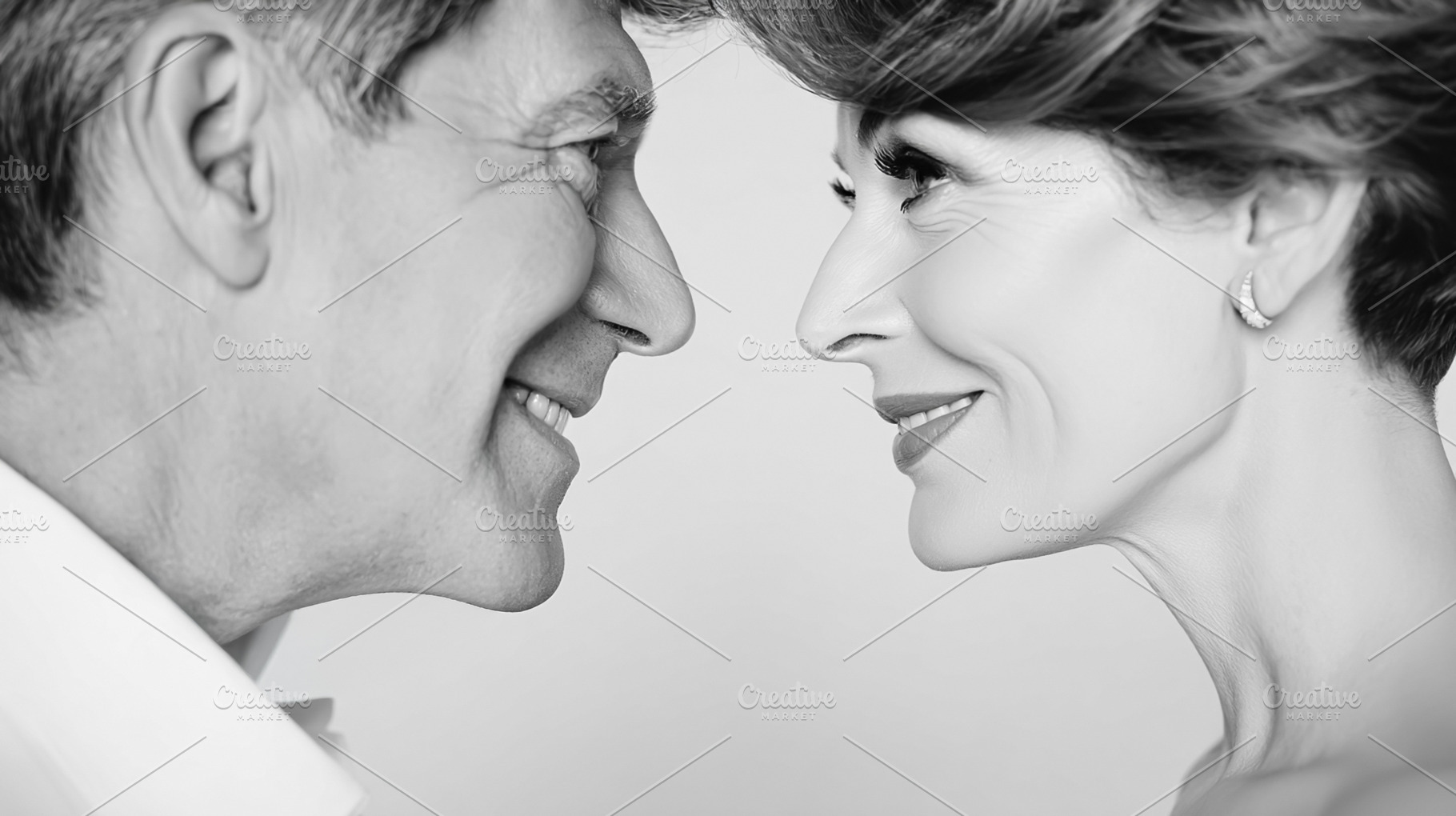 Mature couple sharing loving glance and warm smiles, celebrating, a Photo by Studio ANNA