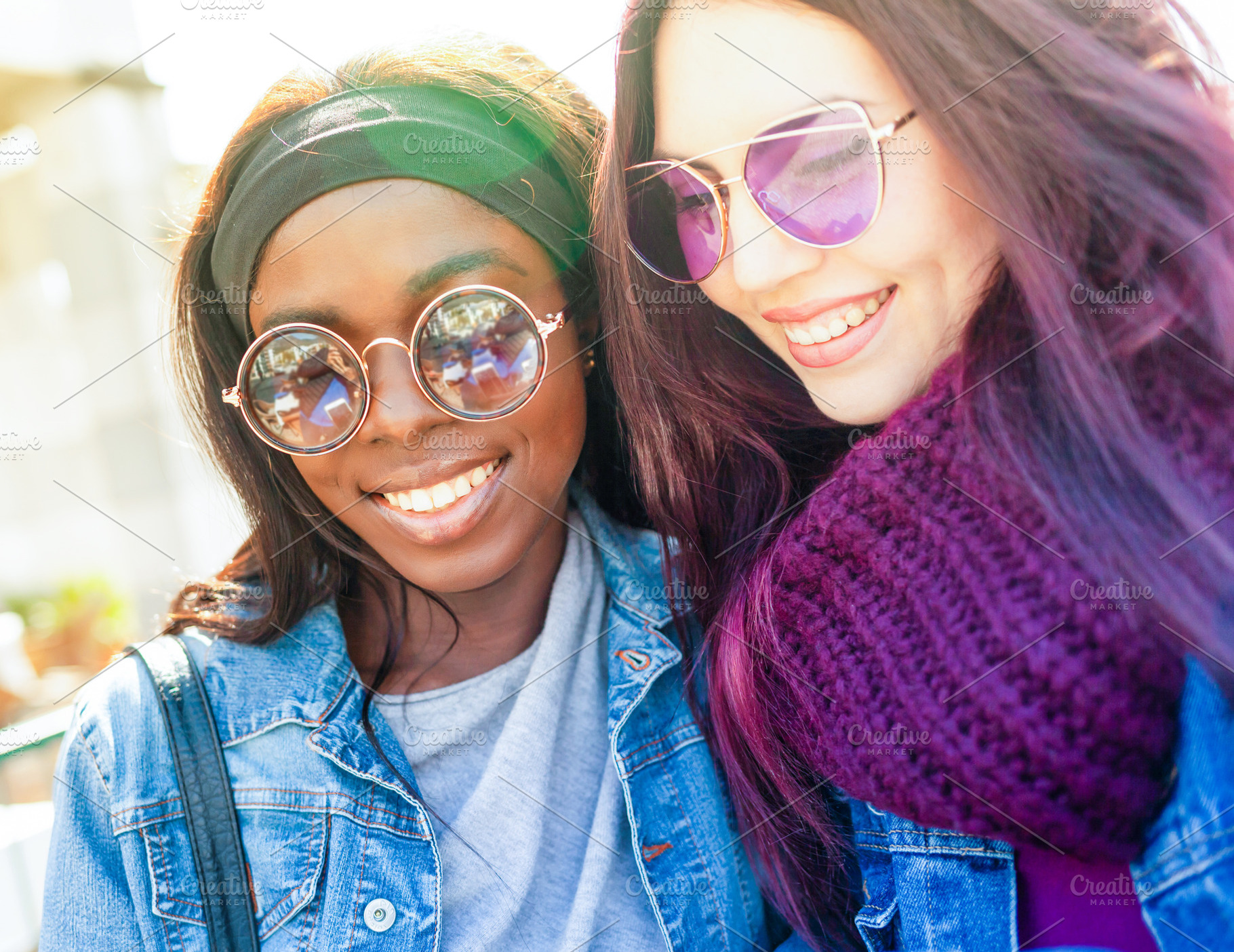 Two smiling young women wearing sunglasses are posing together outdoors, a Person Photo by Antonio Gravante Market