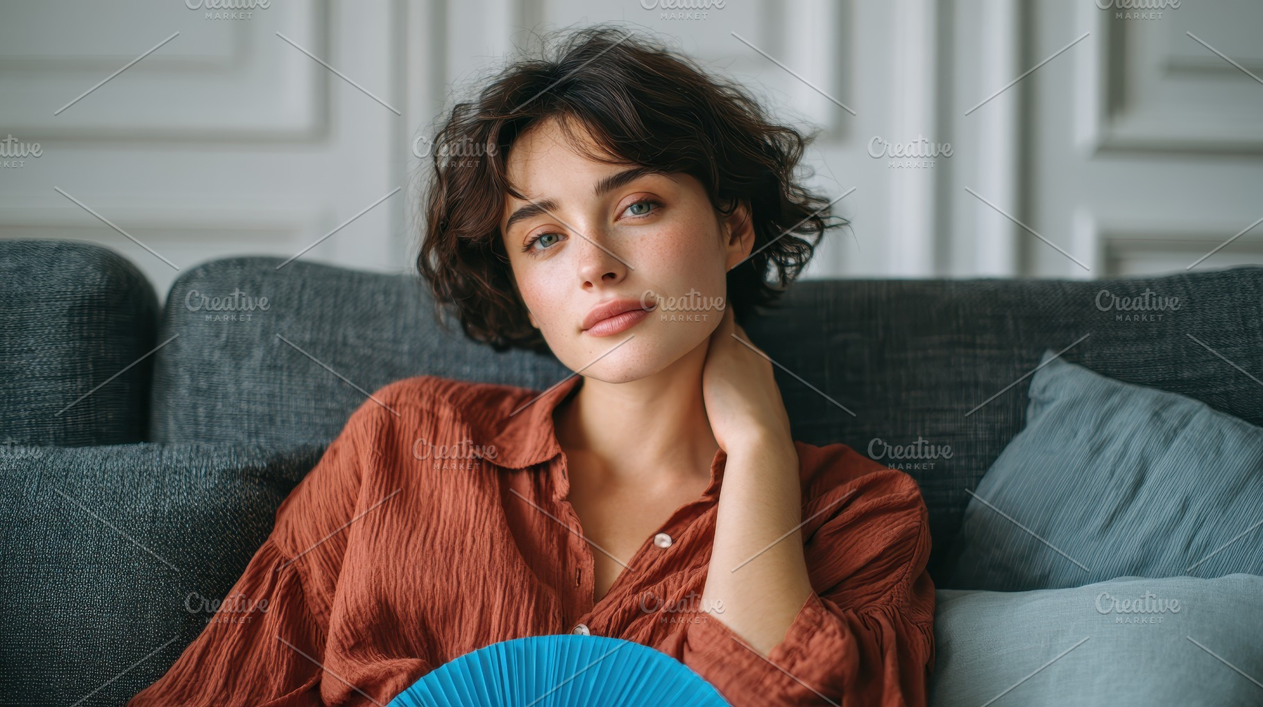 Woman relaxing on couch holding blue, a Photo by Pixeness Studio