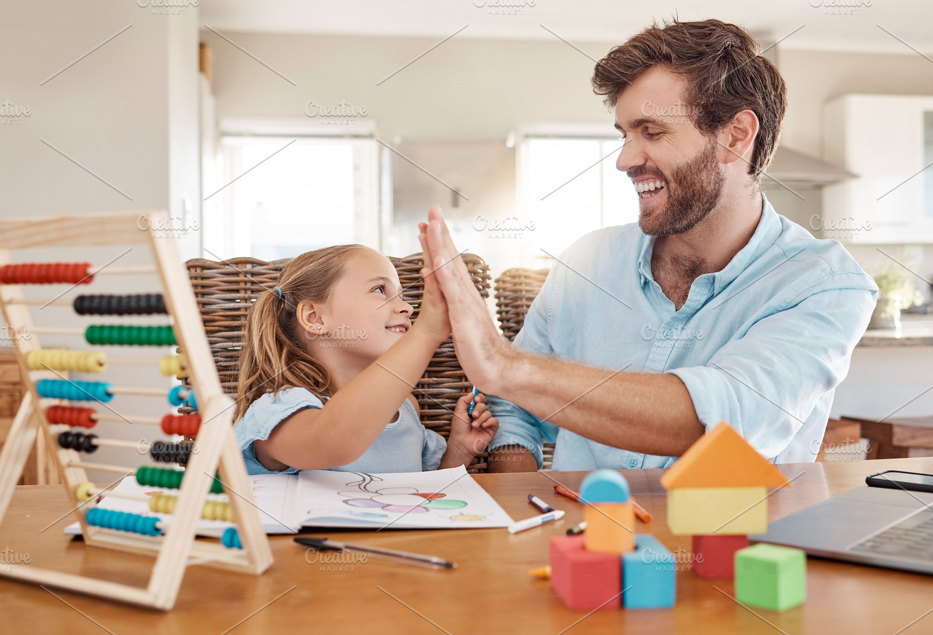 Education, learning and high five by father and girl in homeschooling lesson at kitchen table. Support, teaching and help in child development by parent and daughter winning in homework, abacus math, a Photo by Peopleimages.com