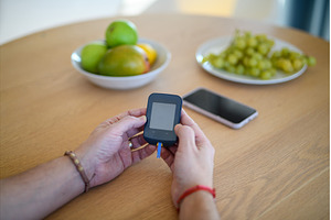 Diabetic man holding blood glucose, a Health & Medical Photo by HalfPoint