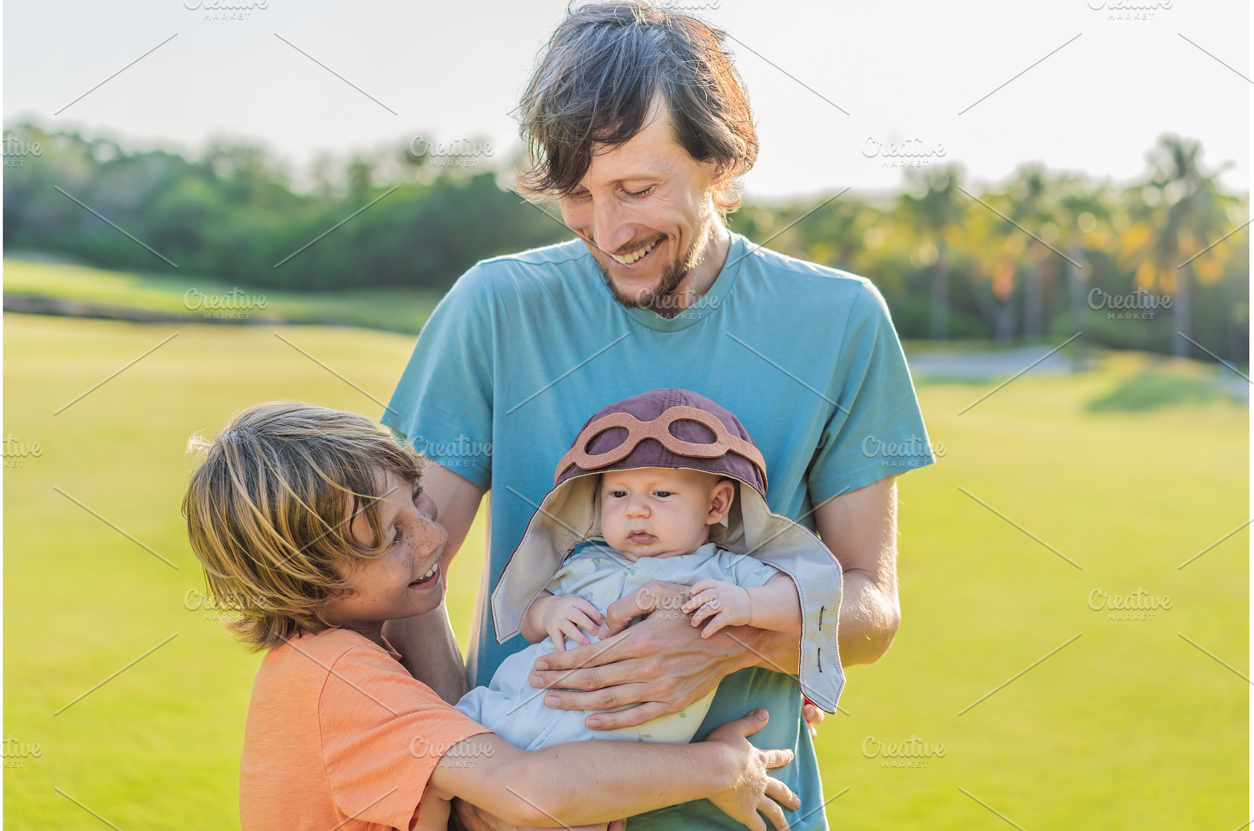 Father, son, and newborn on a meadow, a Person Photo by Elizaveta Galitskaya