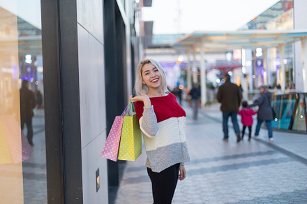 Smiling woman shopping with colorful bags in a modern mall., a Photo by RF Images