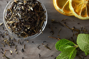 Glass bowl filled with dried tea leaves lemon and mint, a Food & Drink Photo by Davizro's Market