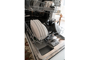 Dishwasher rack full of clean white, a Technology Photo by volodymyrshtun13795