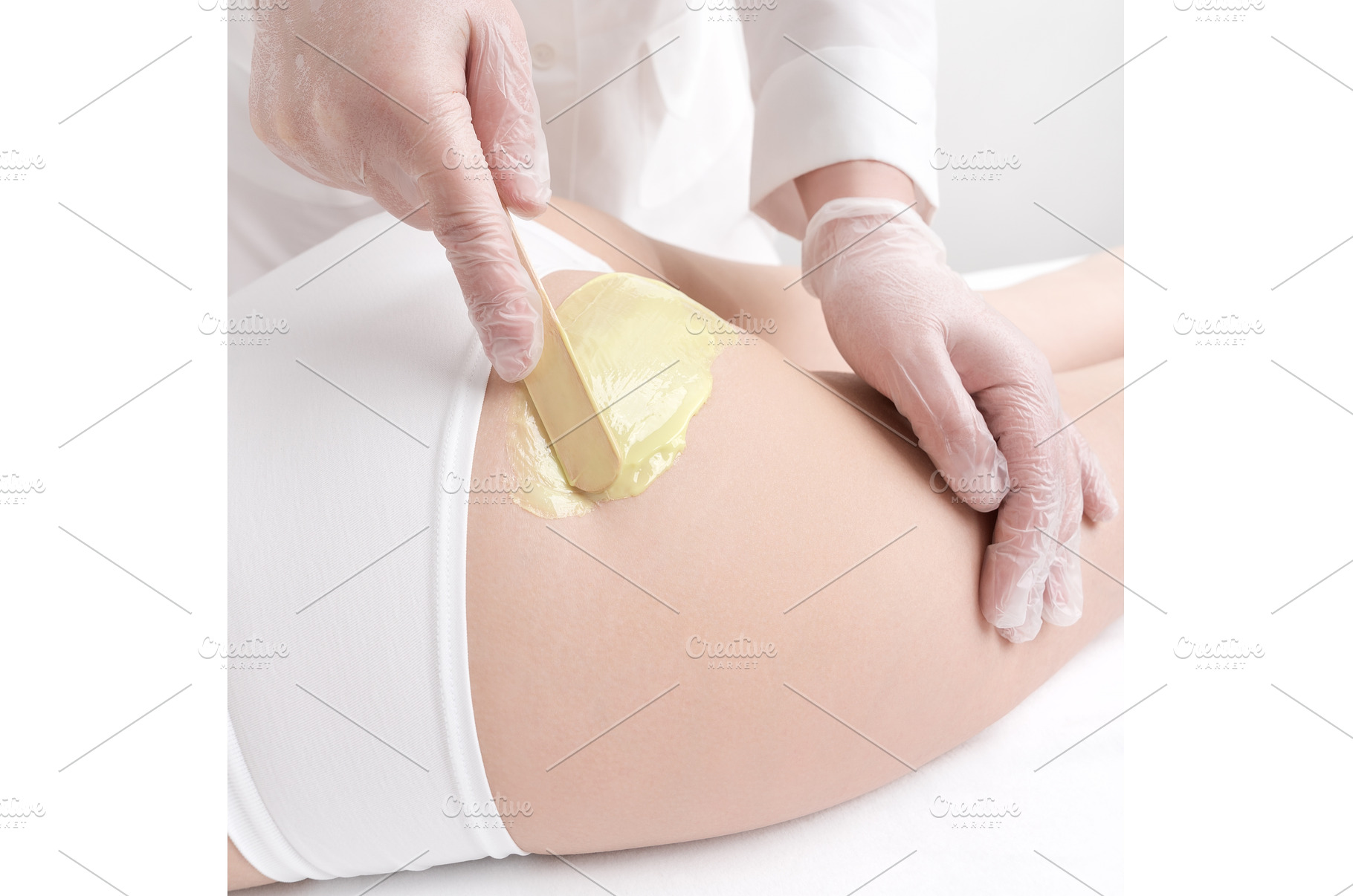 Closeup hand applying hot wax on, a Beauty & Fashion Photo by Alexander-Piragis