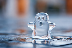 Charming ice ghost figure stands alone on a wet surface in a playful scene, a Photo by AlyaAnd