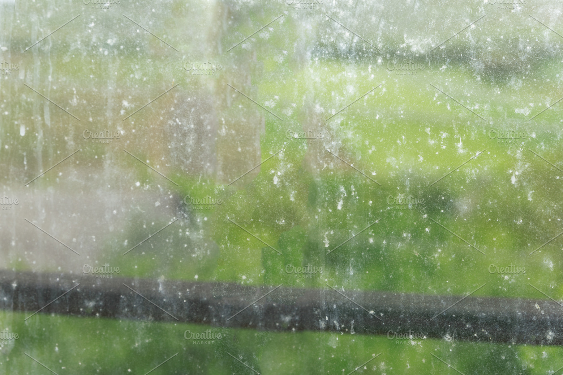 Close-up of a dirty windowpane with water stains and smudges, blurred green bac, a Background Photo by Ales Munt