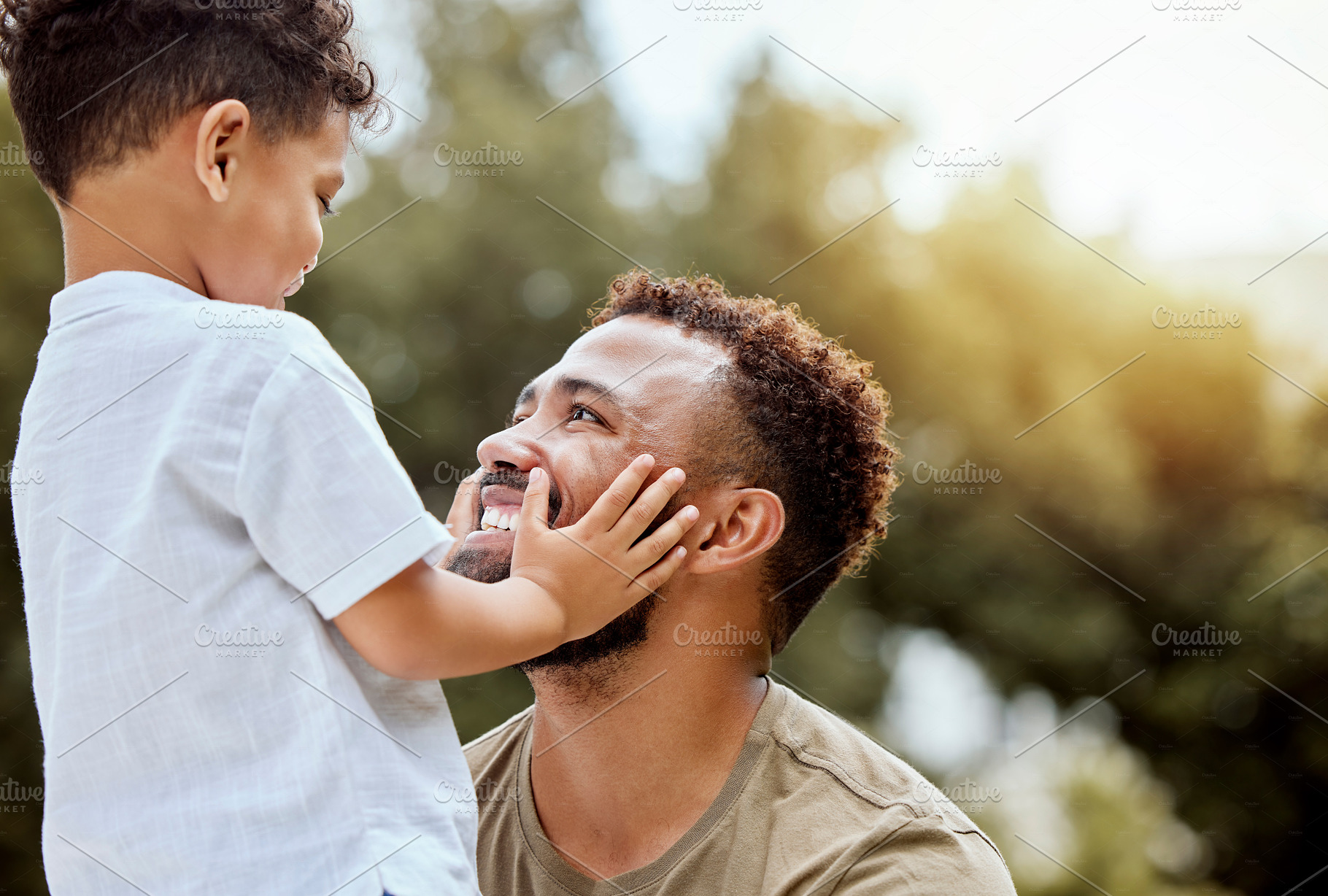 Dad, boy touch face in outdoor park or backyard for summer bonding, happiness together and sunshine. Father son, happy black man in nature for love smile and quality time with child in Los Angeles, a Photo by Peopleimages.com