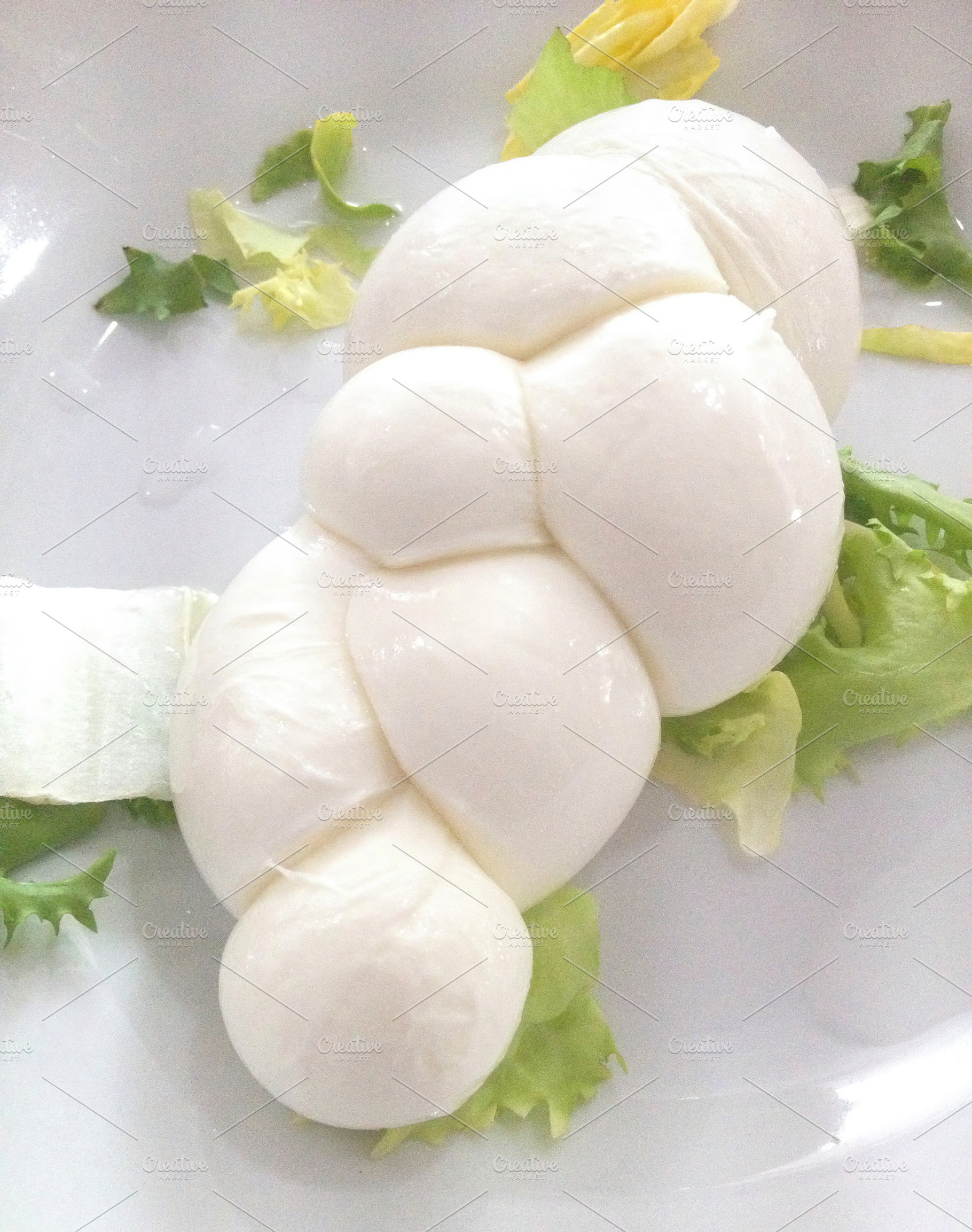 Fresh braided mozzarella cheese with salad on white plate, a Food & Drink Photo by Antonio Gravante Market
