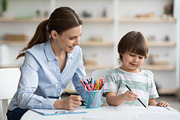 Early development training. Concentrated little boy pupil painting with teacher, a Photo by Prostock-Studio (Thumbnail 2 of 2)