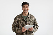 Smiling man in camouflage uniform holding digital tablet, a Photo by Prostock-Studio (Thumbnail 2 of 4)