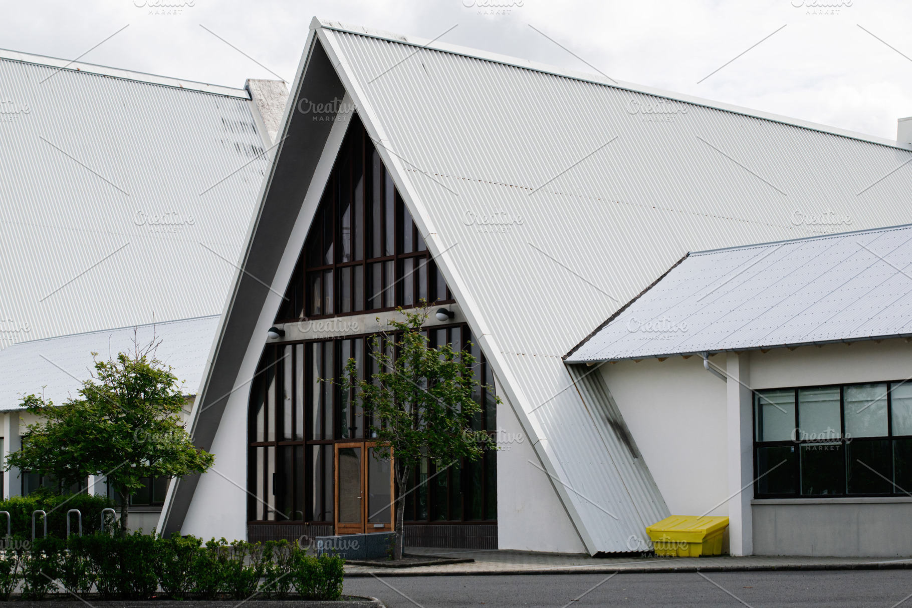 Modern church building with angular roof design in Reykjavik, Iceland under clo, a Photo by AS photostudio