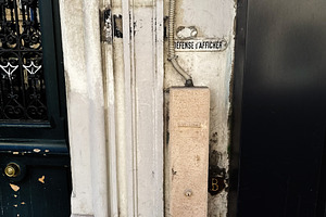 Weathered doorway and vintage sign on a Paris, France building wall with textur, a Photo by AS photostudio