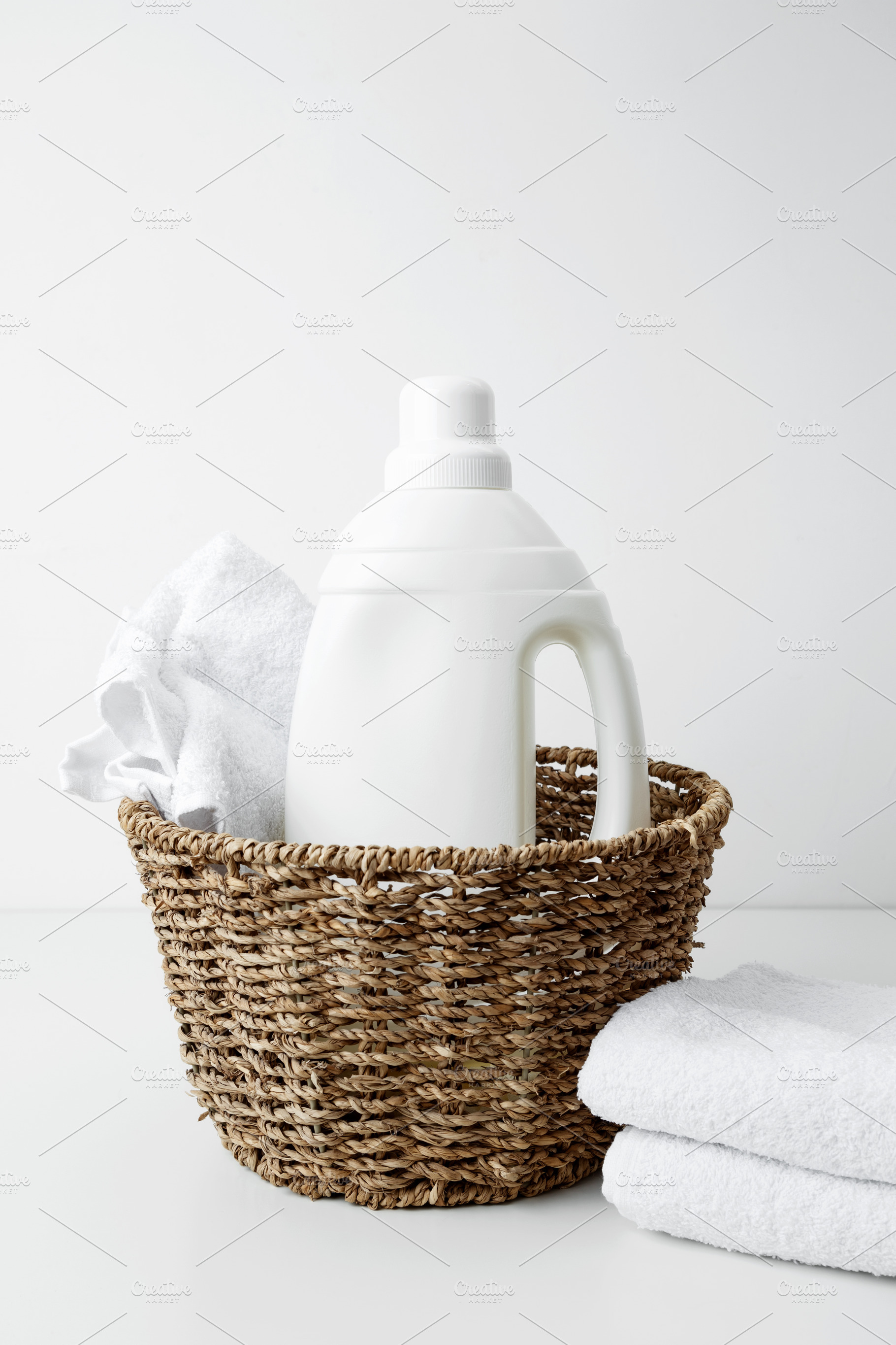 Laundry detergent branding mock up and basket filled with clean white towels. H, a Photo by matucha
