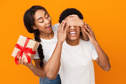 Girl covering boyfriend eyes and, a Person Photo by Prostock-Studio