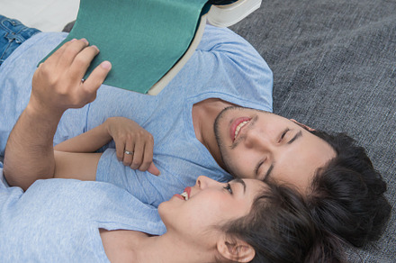 young loving couple reading a book on bedroom at home, a Person Photo by Casanowe-studio