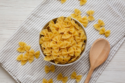 Dry Organic Farfalle Pasta in a Bowl on a white wooden backgroun, a Food & Drink Photo by LiudmylaChuhunova