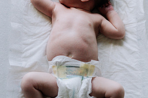 Portrait of a newborn on diapers on a baby changer