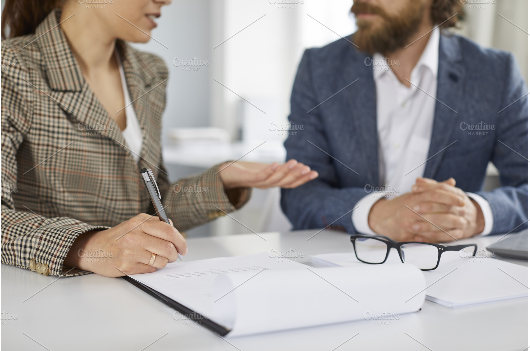 Man and woman sitting at office desk, a Business Photo by StudioRomantic