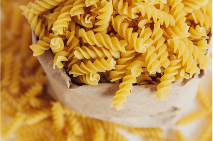 Spiral pasta in a paper bag on a, a Food & Drink Photo by olhovyi_photographer
