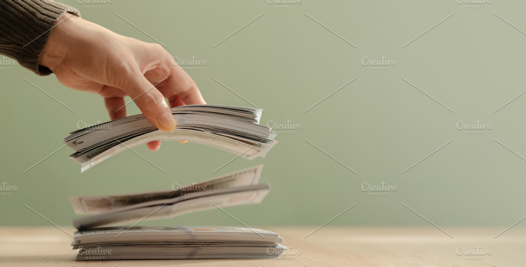 Hand releasing bundles banknotes falling onto stack. Concept of, a Photo by salmon.black